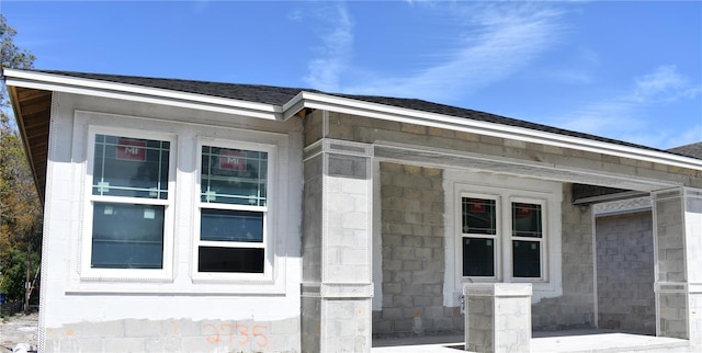 view of property exterior with a shingled roof