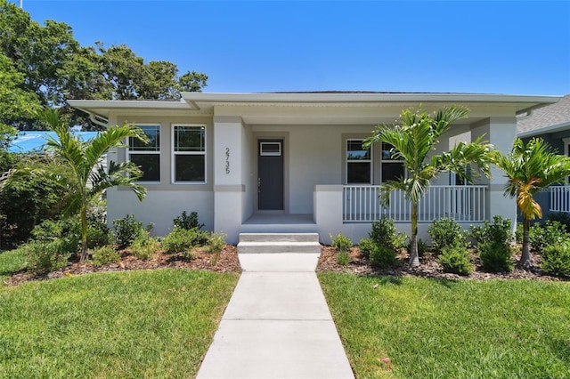 2735 36th Ave N, Saint Petersburg, FL 33713 - view of front of property featuring stucco siding, a porch, and a front lawn