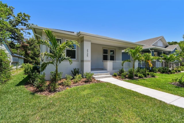 2735 36th Ave N, Saint Petersburg, FL 33713 - ranch-style house with stucco siding, covered porch, and a front yard