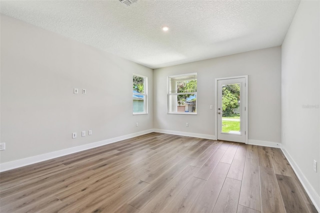 2735 36th Ave N, Saint Petersburg, FL 33713 - unfurnished room featuring a textured ceiling, wood finished floors, and baseboards