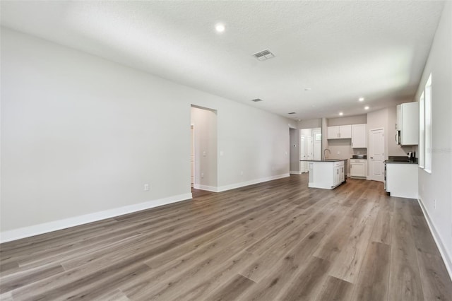 2735 36th Ave N, Saint Petersburg, FL 33713 - unfurnished living room with a sink, wood finished floors, baseboards, and recessed lighting