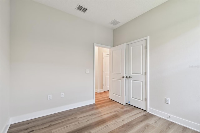 2735 36th Ave N, Saint Petersburg, FL 33713 - unfurnished bedroom featuring light wood-style flooring, baseboards, and a closet