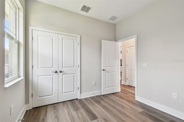 2735 36th Ave N, Saint Petersburg, FL 33713 - unfurnished bedroom with wood finished floors, baseboards, and a closet