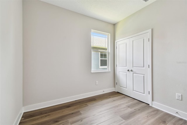 2735 36th Ave N, Saint Petersburg, FL 33713 - unfurnished bedroom with wood finished floors, baseboards, and a closet