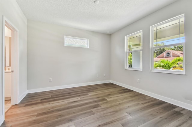 2735 36th Ave N, Saint Petersburg, FL 33713 - spare room featuring wood finished floors, a textured ceiling, and baseboards