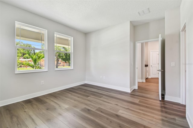 2735 36th Ave N, Saint Petersburg, FL 33713 - unfurnished room with a textured ceiling, wood finished floors, and baseboards