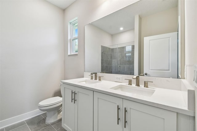 2735 36th Ave N, Saint Petersburg, FL 33713 - bathroom featuring double vanity, toilet, a tile shower, and baseboards
