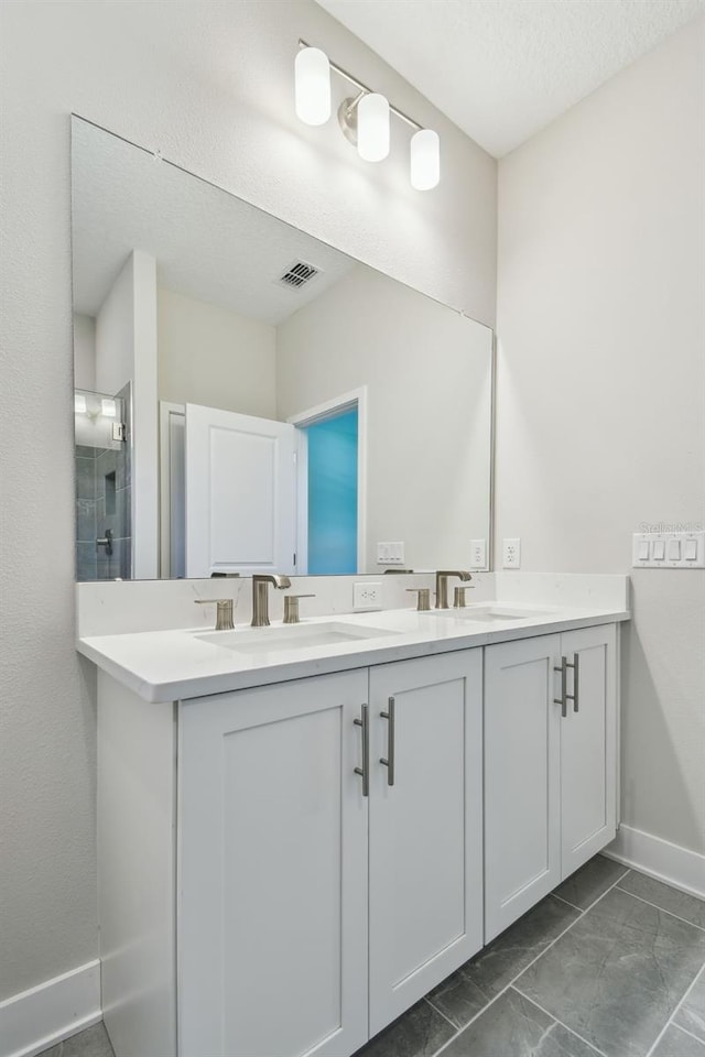 2735 36th Ave N, Saint Petersburg, FL 33713 - full bathroom with double vanity, baseboards, a shower, and a textured ceiling