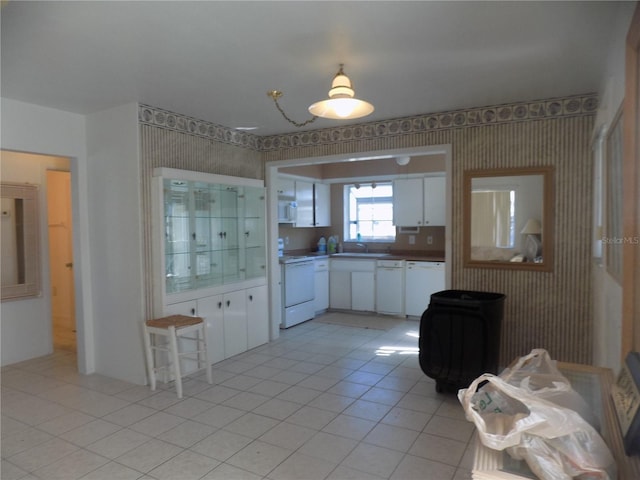 kitchen with sink, white cabinets, white appliances, and light tile patterned floors