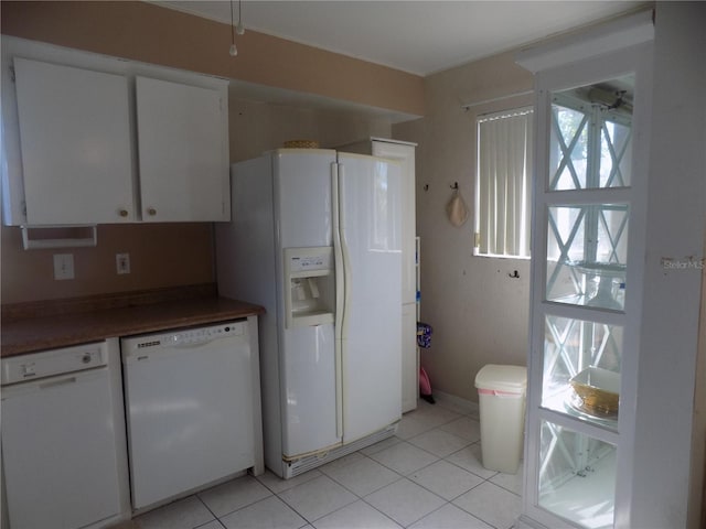 kitchen featuring white cabinets, light tile patterned floors, and white appliances