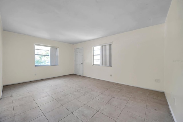 spare room with plenty of natural light and light tile patterned floors