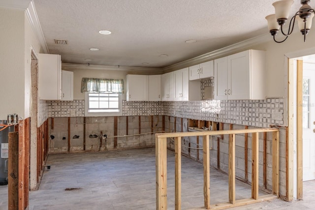 4211 Shore Acres Blvd NE, Saint Petersburg, FL 33703 - kitchen featuring ornamental molding, white cabinets, a textured ceiling, a chandelier, and light wood finished floors