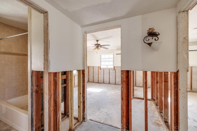 hallway featuring a textured ceiling and tile walls