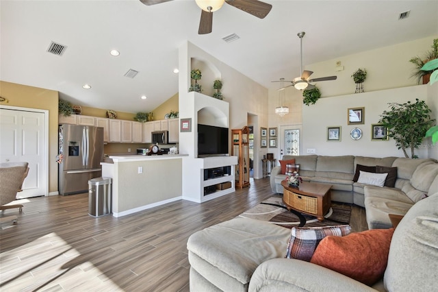 living room with hardwood / wood-style floors, high vaulted ceiling, and ceiling fan