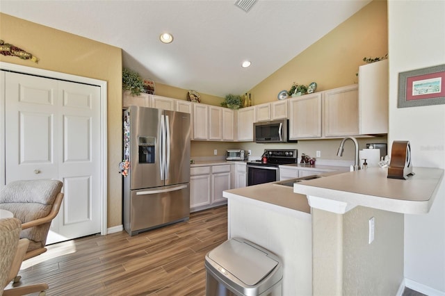 kitchen with kitchen peninsula, light wood-type flooring, stainless steel appliances, and high vaulted ceiling