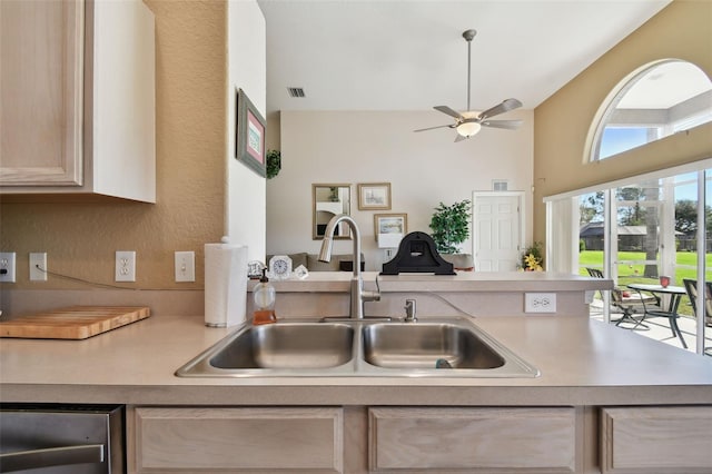 kitchen with ceiling fan, light brown cabinets, sink, and a high ceiling