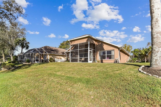 rear view of house featuring a lawn and a sunroom