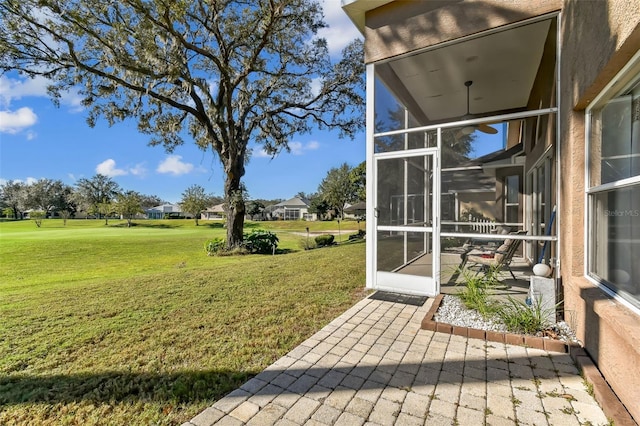 view of yard featuring a sunroom and a patio