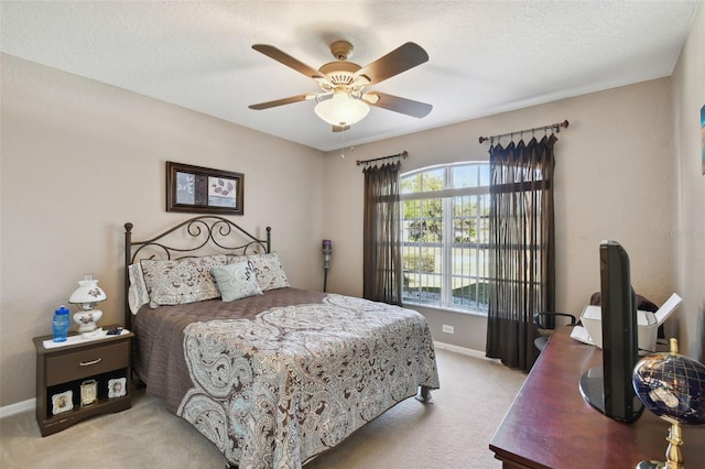 carpeted bedroom featuring ceiling fan and a textured ceiling