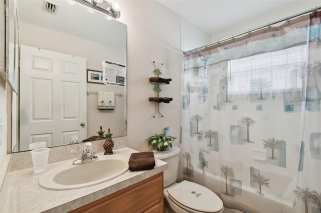 full bathroom featuring vanity, shower / bath combination with curtain, and toilet