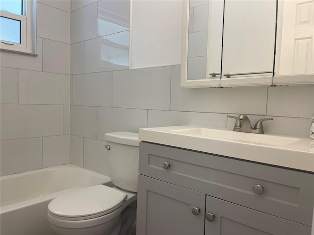 full bathroom featuring washtub / shower combination, toilet, decorative backsplash, vanity, and tile walls