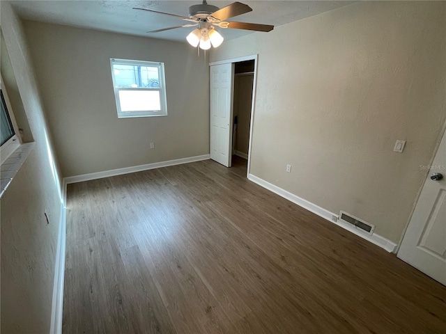 unfurnished bedroom featuring ceiling fan, a closet, and hardwood / wood-style flooring