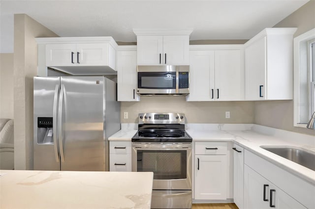 kitchen with sink, white cabinets, and appliances with stainless steel finishes