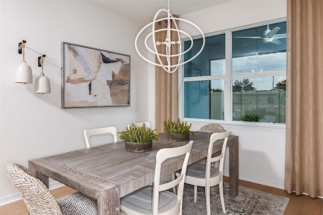 dining area featuring hardwood / wood-style floors and ceiling fan with notable chandelier