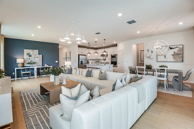 living room with light hardwood / wood-style flooring and a chandelier