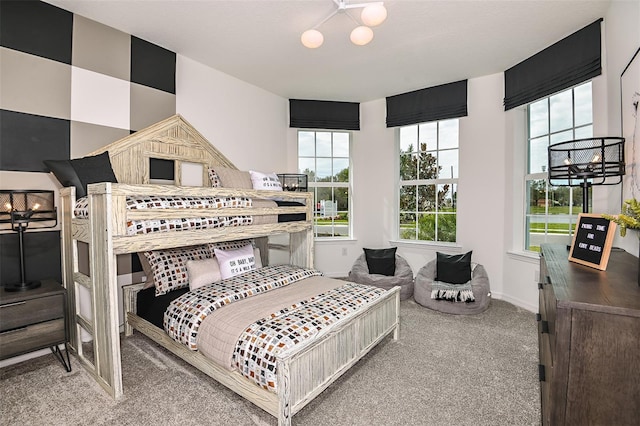 carpeted bedroom with multiple windows and an inviting chandelier