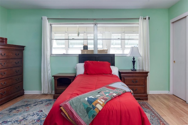 bedroom with light hardwood / wood-style floors and a closet