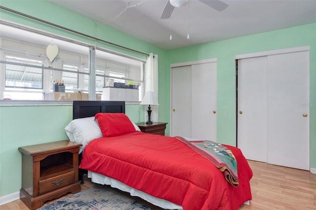 bedroom with multiple closets, ceiling fan, and light hardwood / wood-style flooring