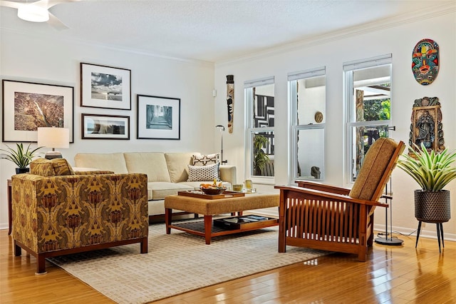 sitting room with hardwood / wood-style floors, a textured ceiling, ceiling fan, and ornamental molding