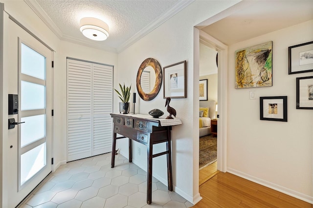 doorway to outside featuring a textured ceiling, light wood-type flooring, and crown molding