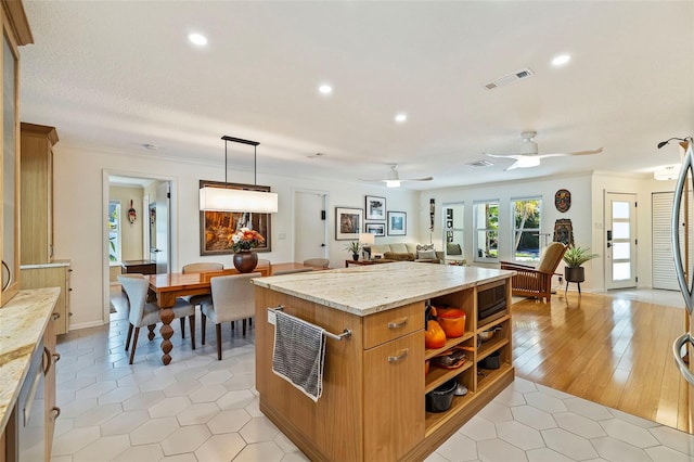 kitchen with pendant lighting, light hardwood / wood-style flooring, ceiling fan, ornamental molding, and light stone counters