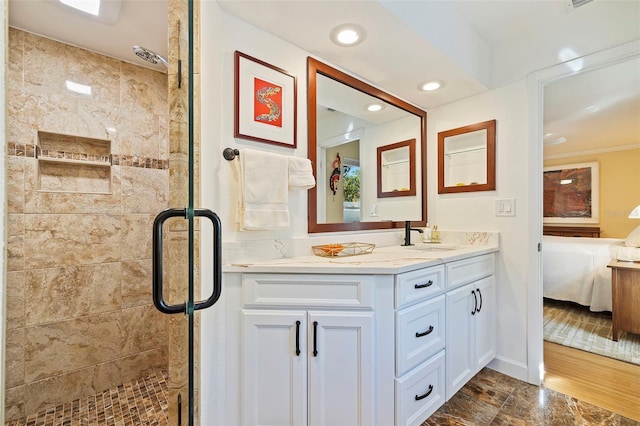 bathroom featuring hardwood / wood-style flooring, vanity, ornamental molding, and walk in shower