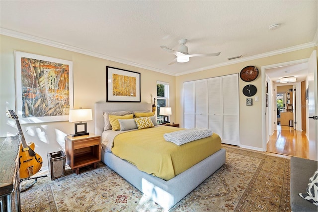 bedroom with multiple windows, a closet, ceiling fan, and hardwood / wood-style flooring