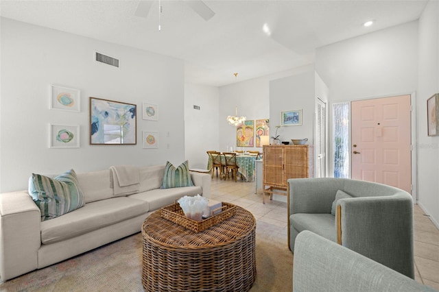 tiled living room with ceiling fan and a high ceiling