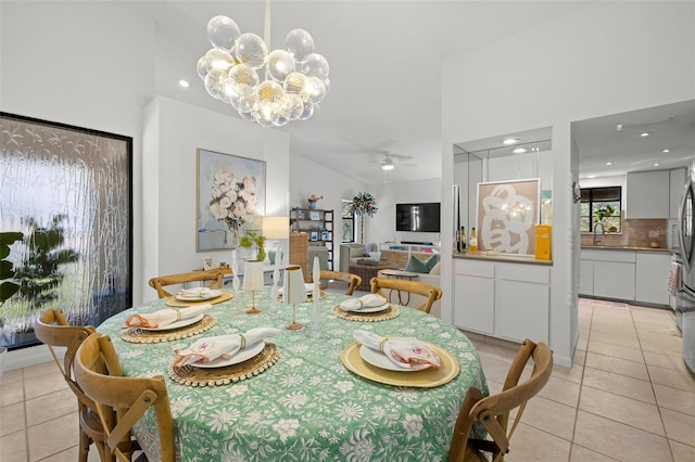 tiled dining space with ceiling fan with notable chandelier