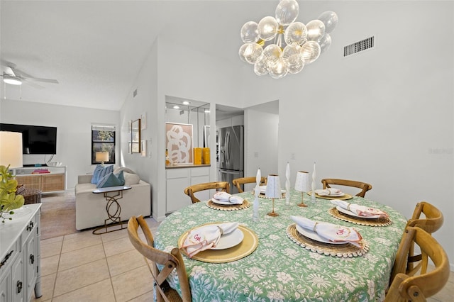 dining room featuring light tile patterned floors, ceiling fan with notable chandelier, and high vaulted ceiling