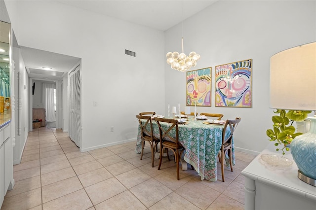 dining room with a chandelier, a high ceiling, and light tile patterned flooring