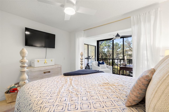 bedroom featuring access to exterior, ceiling fan, and a textured ceiling