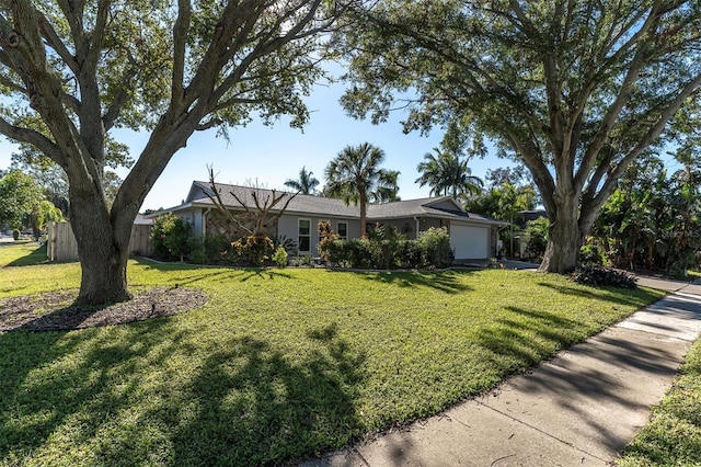 ranch-style home with a garage and a front lawn