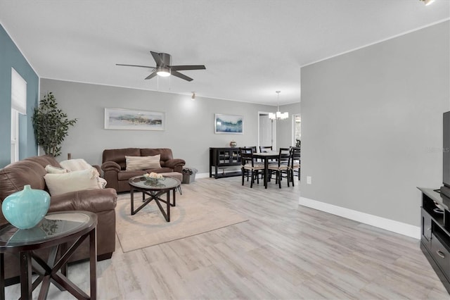 living room featuring light hardwood / wood-style floors and ceiling fan with notable chandelier