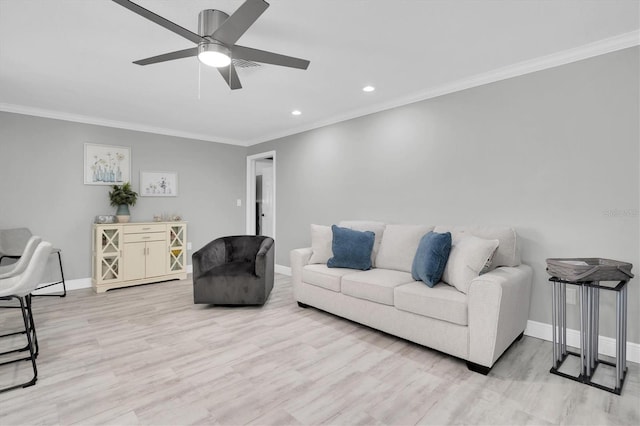 living room featuring ceiling fan, light wood-type flooring, and ornamental molding