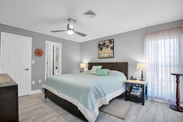 bedroom featuring ceiling fan, a textured ceiling, and light wood-type flooring