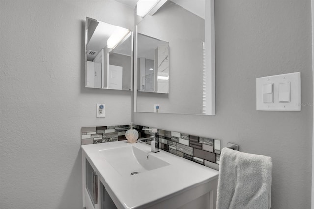 bathroom with decorative backsplash and vanity