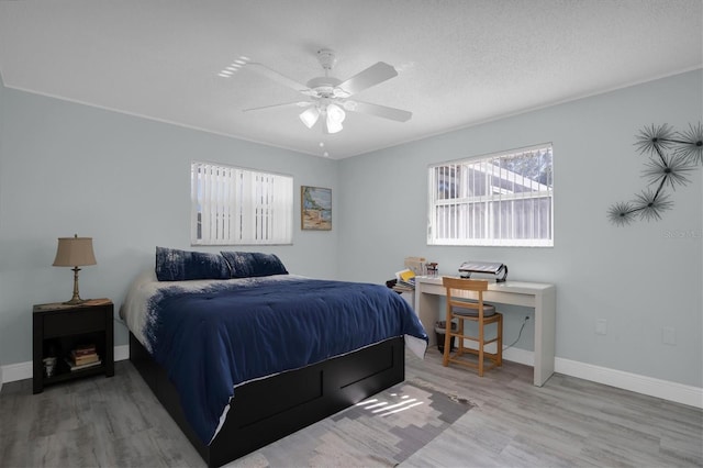 bedroom with ceiling fan, a textured ceiling, and hardwood / wood-style flooring