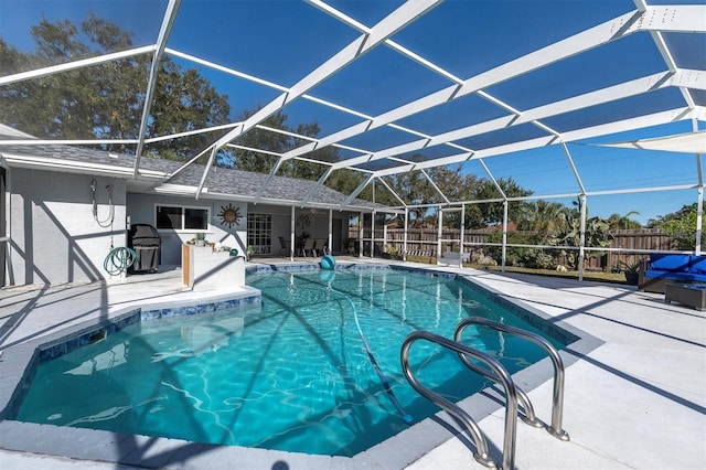 view of swimming pool featuring glass enclosure and a patio