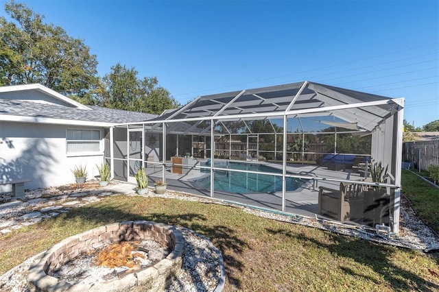 rear view of house featuring a fire pit, a patio area, a lanai, and a yard